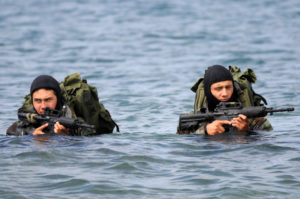 U.S. Sailors enrolled in the basic underwater demolition/SEAL (BUD/S) course approach the shore during an over-the-beach exercise in San Clemente Island, Calif., June 24, 2009. The exercise is designed to prepare Navy SEALs for missions that begin in the water before transitioning to land. The students, who are in the third phase of BUD/S training, are learning weapons tactics, demolition, land navigation and patrolling techniques. (DoD photo by Mass Communication Specialist 2nd Class Kyle D. Gahlau, U.S. Navy/Released)