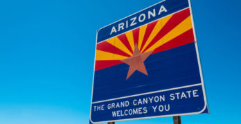 Arizona state border highway sign with a sky blue background