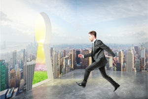 Businessman in city running towards abstract keyhole opening leading to nature. Escape concept
